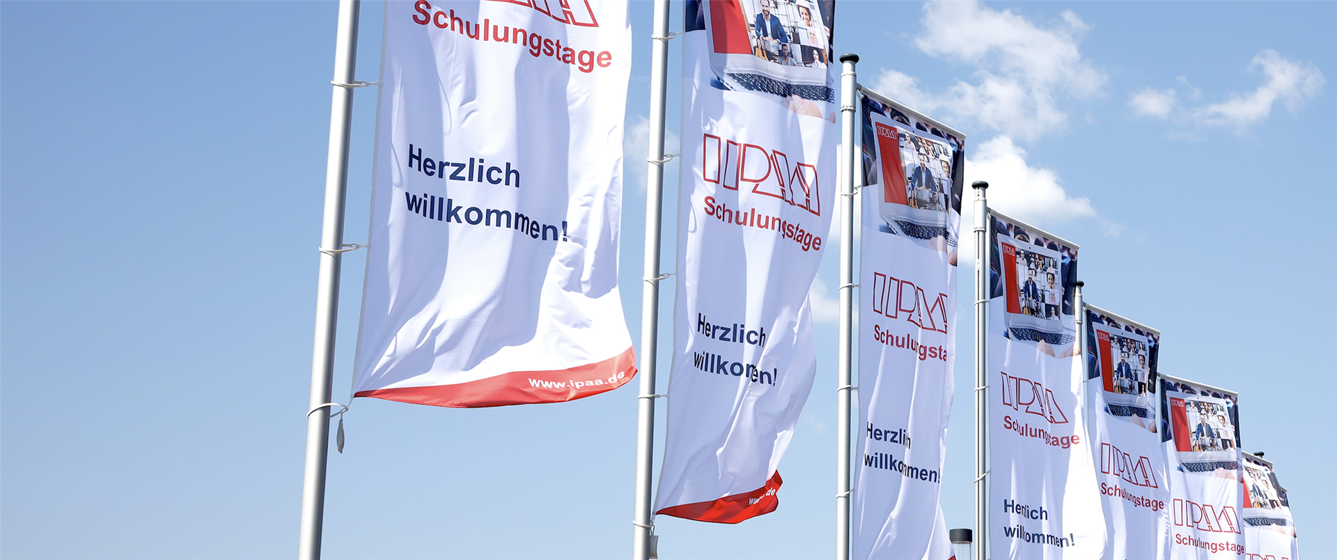 IPAA-Fahnen im Wind vor strahlend blauem Himmel