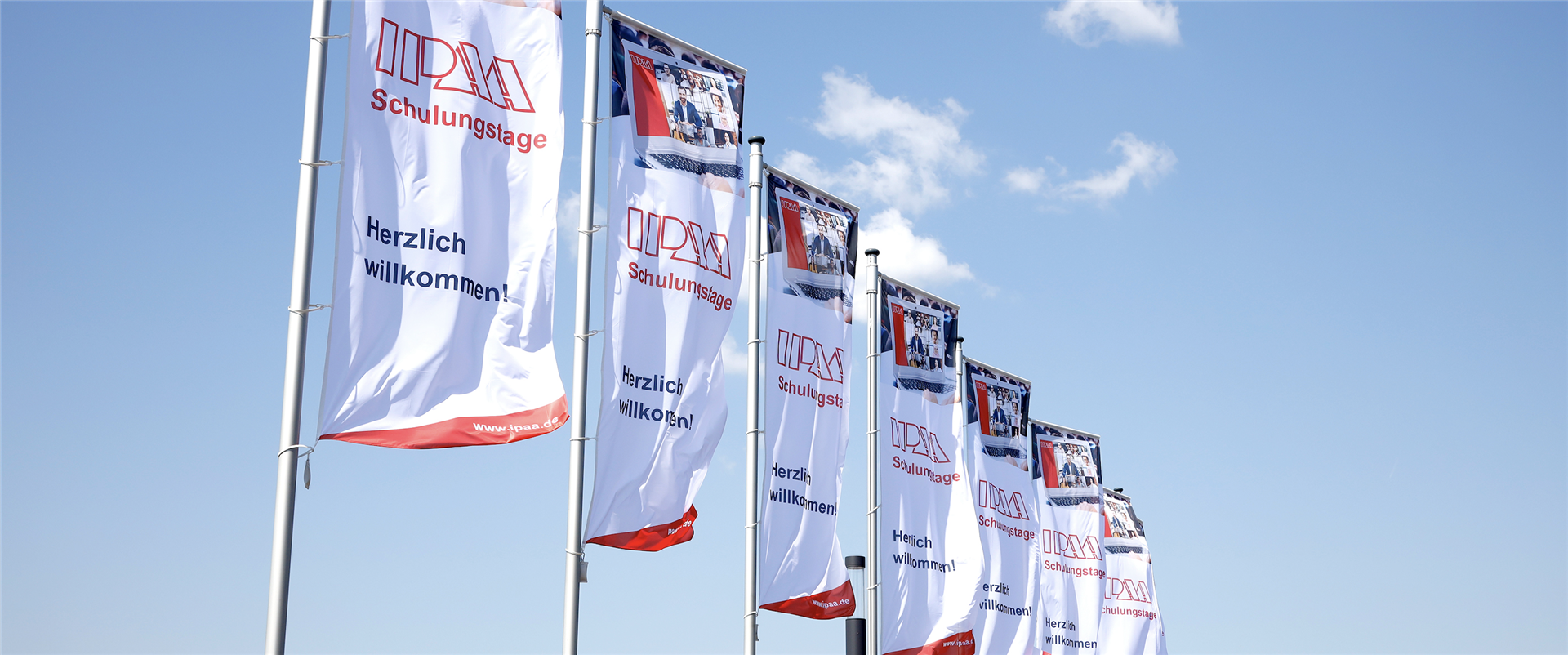 IPAA-Fahnen im Wind vor strahlend blauem Himmel