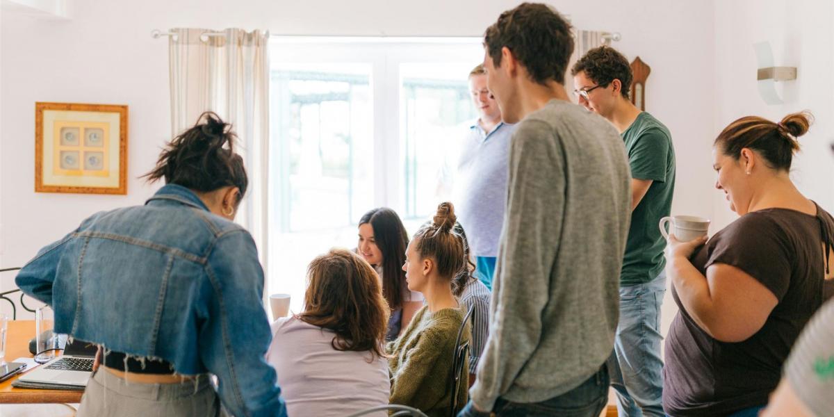 Fünf Personen, Die In Der Nähe Von Vier Personen Stehen, Die In Der Nähe Des Schreibtisches Sitzen
