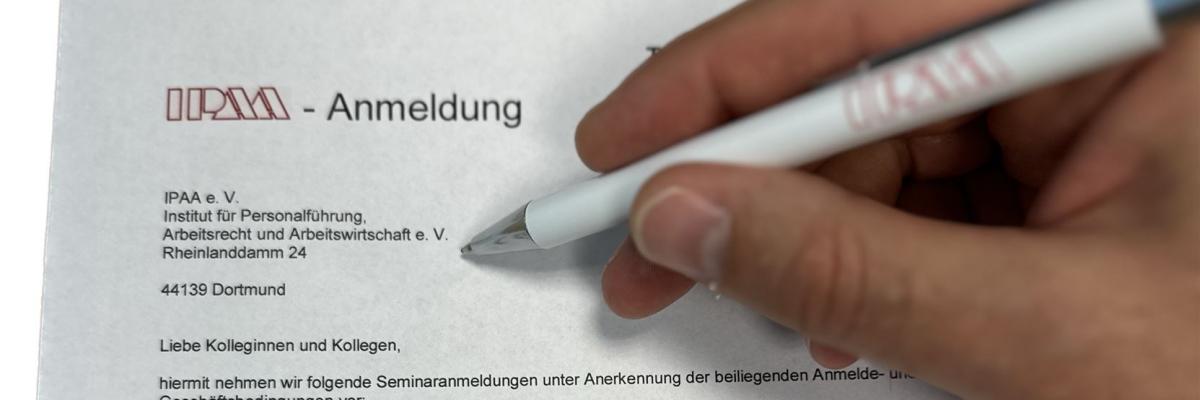 Eine Hand die mit einem Kugelschreiber ein IPAA-Anmeldeformular ausfüllt